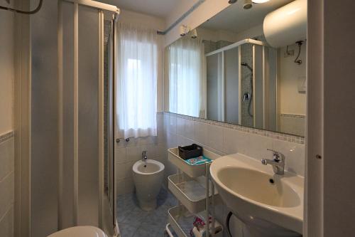 a bathroom with a sink and a toilet and a mirror at Casa Elena in Breuil-Cervinia