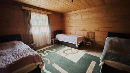 a room with two beds in a wooden cabin at Family Guesthouse Bako in Bako