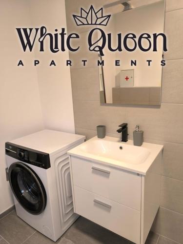 a white bathroom with a washing machine and a sink at White Quenn Apartments in Sanski most