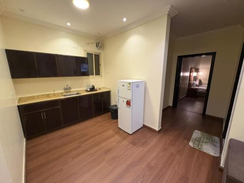 eine Küche mit einem weißen Kühlschrank in einem Zimmer in der Unterkunft لؤلؤة الثريا للشقق المخدومة فرع العقيق in Riad