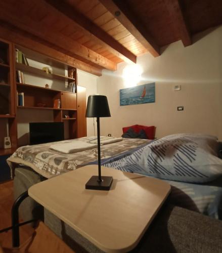a room with two beds and a table with a lamp at B&B Raggio di sole in Muggia