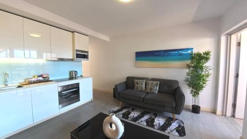 a living room with a couch and a kitchen at The Padbury Suites-Premium City Apartment in Karratha