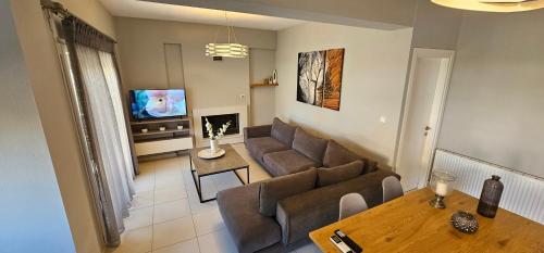 a living room with a couch and a table at ELINOR on the beach in Flogita