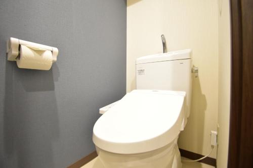 a bathroom with a toilet and a roll of toilet paper at Alphabed広島平和大通り in Hiroshima