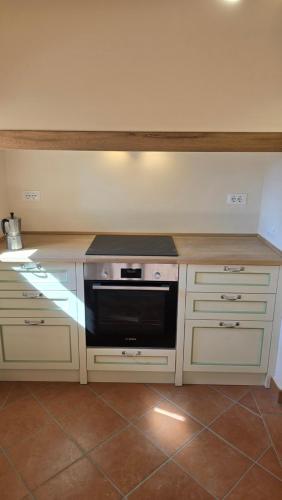 a kitchen with white cabinets and a black oven at Castello di Vecchienna in Monterotondo