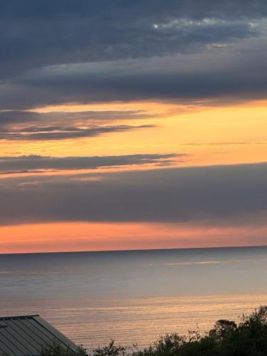 a view of the ocean at sunset at The Garden Pool and Spa house ocean views in Seacliff