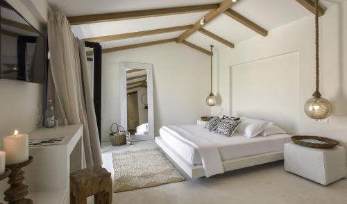 a white bedroom with a bed and a mirror at Kefalonia Grand in Argostoli