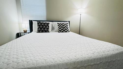 a bedroom with a large white bed with pillows at Lavish Escape in Charlotte