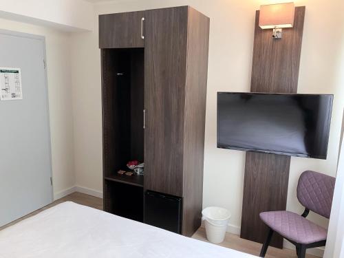 a hotel room with a tv and a bed at Hotel Fährhaus km734 in Düsseldorf