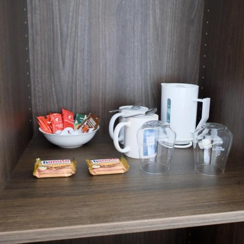 a shelf with a coffee maker and a bowl of food at Hotel Fährhaus km734 in Düsseldorf