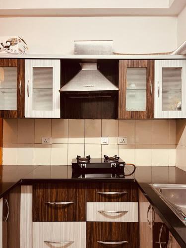cocina con armarios de madera y fogones en Springs Forever, en Gachibowli