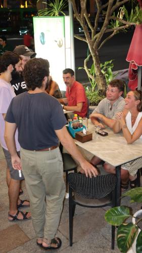 a group of people sitting at a table at The Little Leaf Hostel - Restaurant and Rooftop Bar in Cat Ba