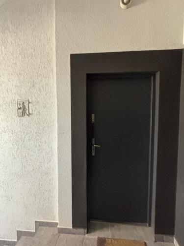 a black door in a room with stairs at Apartamenty Łuczkowskiego z widokiem na Studnię 5 in Chełm