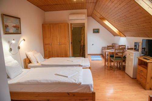 a room with two beds and a dining room at Haramia Csapszék és Fogadó in Szombathely