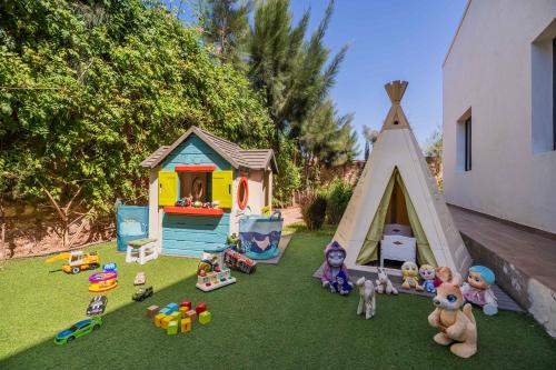 a group of toys sitting on the grass next to a tent at Villa La Rose Bleue - Résidence Hôtelière avec Piscine - Essaouira in Essaouira