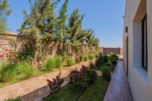 a garden with plants and flowers next to a building at Villa La Rose Bleue - Résidence Hôtelière avec Piscine - Essaouira in Essaouira