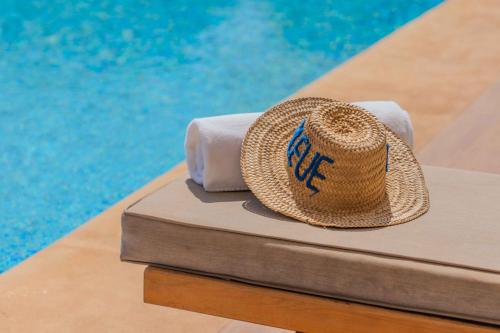 a straw hat sitting next to a swimming pool at Villa La Rose Bleue - Résidence Hôtelière avec Piscine - Essaouira in Essaouira
