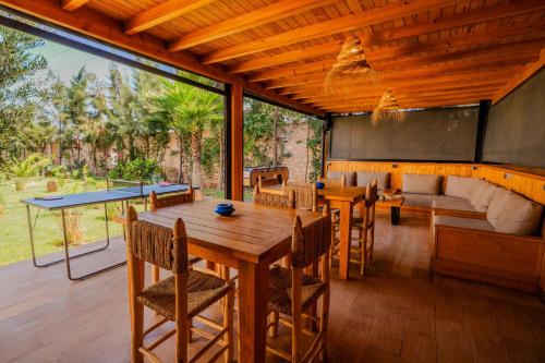 a living room with a wooden table and chairs at Villa La Rose Bleue - Résidence Hôtelière avec Piscine - Essaouira in Essaouira