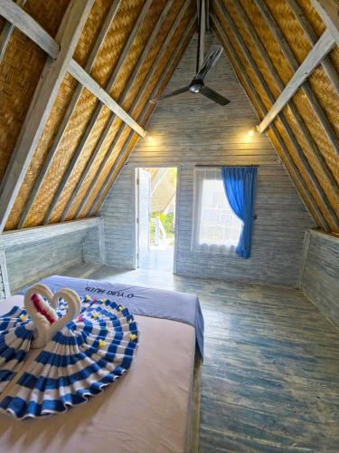 a bedroom with a bed in a room with a ceiling at D'Yuki Huts Lembongan in Nusa Lembongan