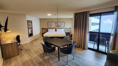a hotel room with a bed and a table and chairs at Holiday Inn Fortaleza by IHG in Fortaleza