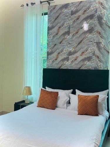 ein Schlafzimmer mit einem weißen Bett und einer Steinmauer in der Unterkunft Shanty Town Homes in Kampala