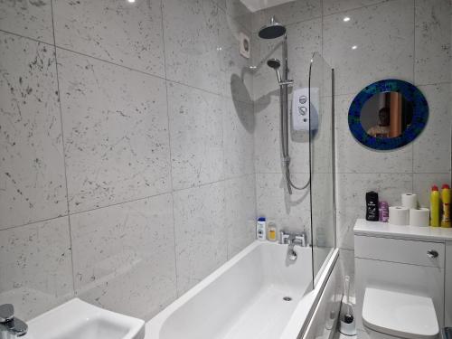 a bathroom with a shower and a tub and a toilet at Stella Lounge in Idle