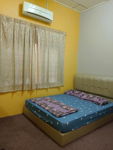 Un dormitorio con una cama en una habitación con ventana. en Addin Homestay Tanah Merah, en Tanah Merah