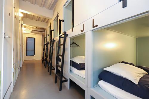 a hallway with a row of bunk beds at E10Hostel in Tokyo
