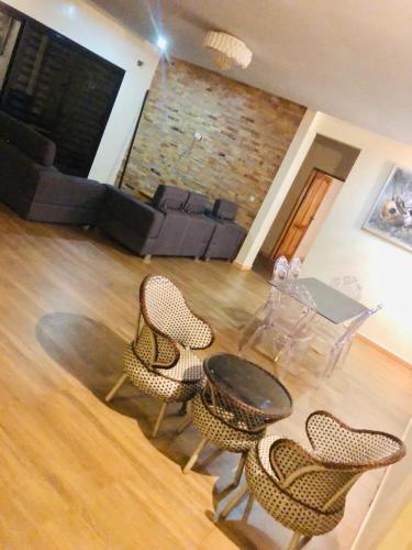 a living room with a table and chairs and a couch at Hotel le Mbosse in Niaga
