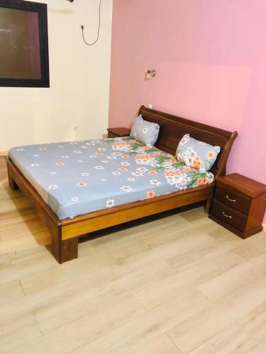 a bedroom with a bed with a blue comforter at Hotel le Mbosse in Niaga