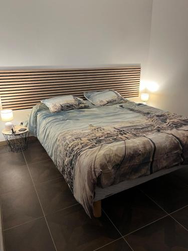un grand lit dans une chambre avec deux lampes dans l'établissement La Maison 91, 