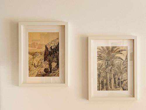 two framed pictures of palm trees on a wall at Holiday in Playa Calera - Swimming pool in Valle Gran Rey