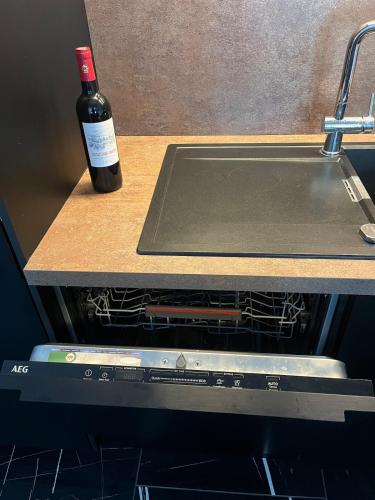 une bouteille de vin posée sur un comptoir à côté d'un four dans l'établissement La Maison 91, 