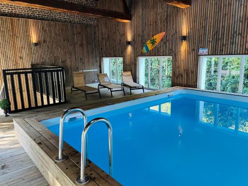 a swimming pool in a house with chairs at House in a residence with swimming pool near Le Touquet Paris Plage in Saint-Josse