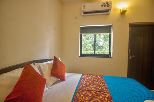 a bedroom with a bed with a window at Amazing Pool View 2BHK Candolim Goa Apartment in Candolim