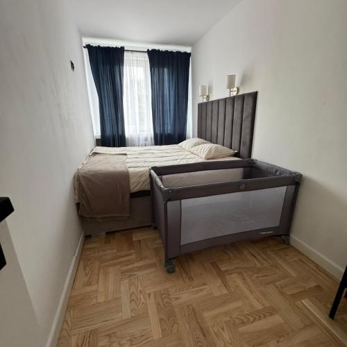 a small bedroom with a bed and a wooden floor at Marszałkowska City Center Apartment With Working Space in Rzeszów