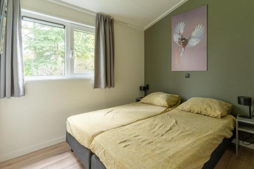 a bedroom with two beds and a window at Nieuw! 6-persoons chalet aan het Veluwemeer dichtbij Harderwijk, Amersfoort en Zwolle in Hulshorst