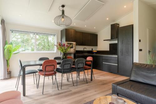 a kitchen and living room with a table and chairs at Nieuw! 6-persoons chalet aan het Veluwemeer dichtbij Harderwijk, Amersfoort en Zwolle in Hulshorst