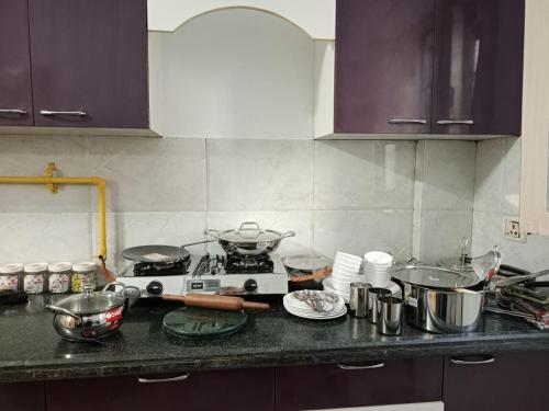 a kitchen counter with a stove and pots and pans at Gharanda Home Stay in Jāmb