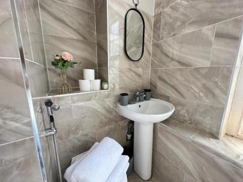 a bathroom with a sink and a mirror at Edgware Road Beautiful Family Apartment in London