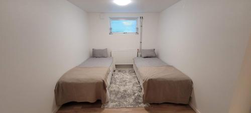 two beds in a small room with a window at Modern apartment near Volvo Cars in Torslanda