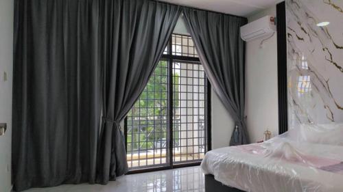 a bedroom with a bed and a large window at Bukit Indah Homestay in Johor Bahru