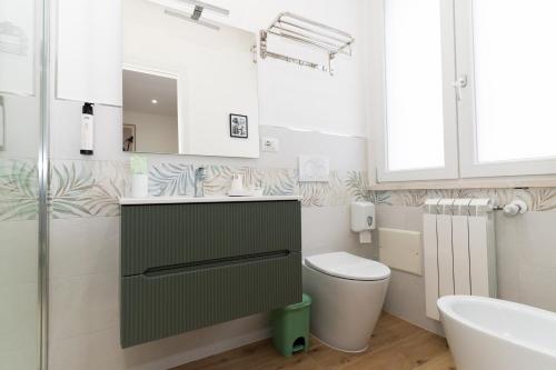 a white bathroom with a toilet and a sink at Casa Francesca in Sassari