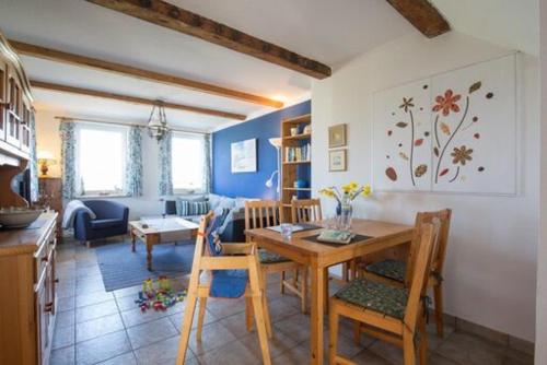 una cucina e un soggiorno con tavolo e sedie di Nice Holidays a Pellworm