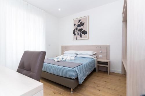 a bedroom with a bed with a chair and a desk at Casa Francesca in Sassari