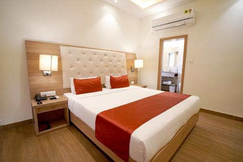 a hotel room with a large bed with red pillows at Kalinga Hotel in Jodhpur