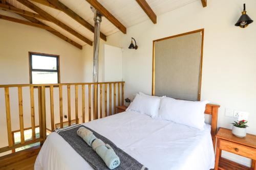 a bedroom with a white bed with a wooden headboard at Rolling Hills Farmstead in Caledon