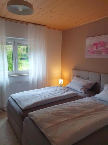 a bedroom with two beds and a window at Wünschel Stube in Gossersweiler-Stein
