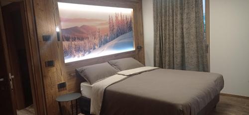 een slaapkamer met een bed en een raam met een foto bij Chalet Radola in Campitello di Fassa