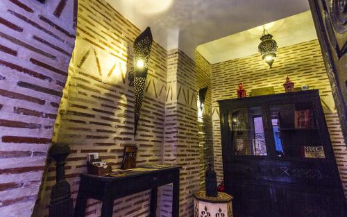 Habitación con pared de madera, mesa y luces. en Riad Maud, en Marrakech